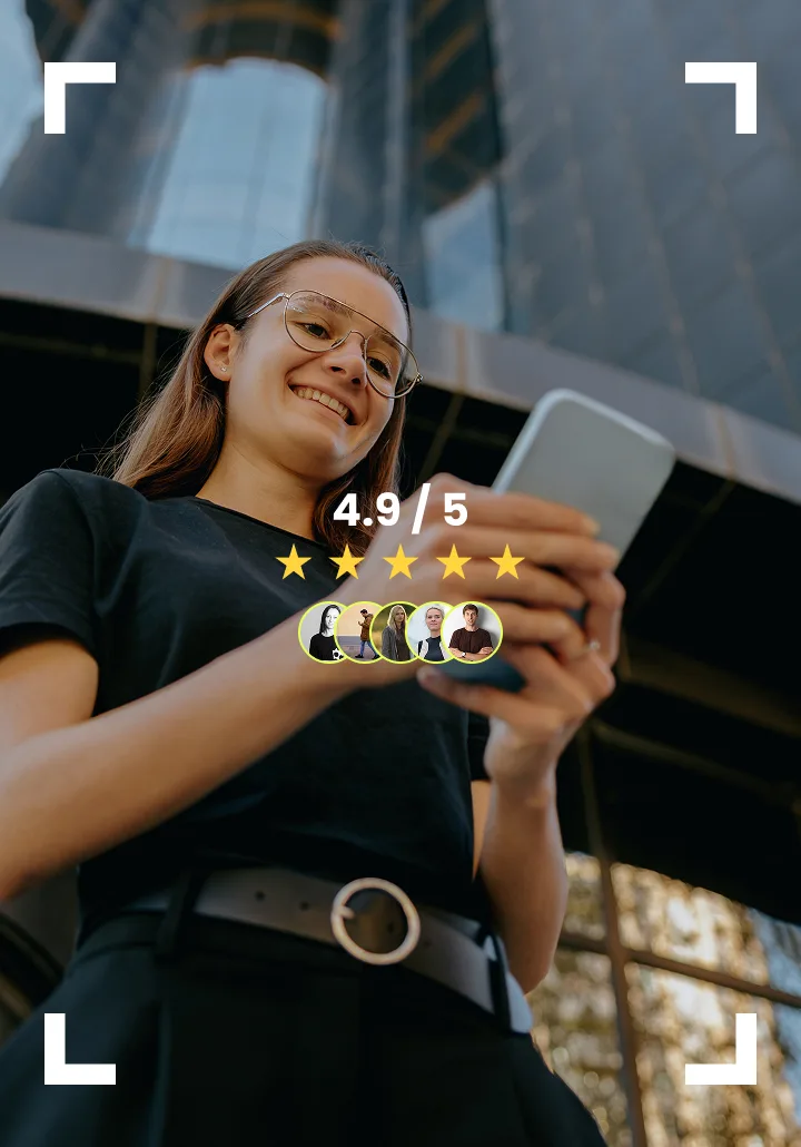 Smiling person holding phone with QR code